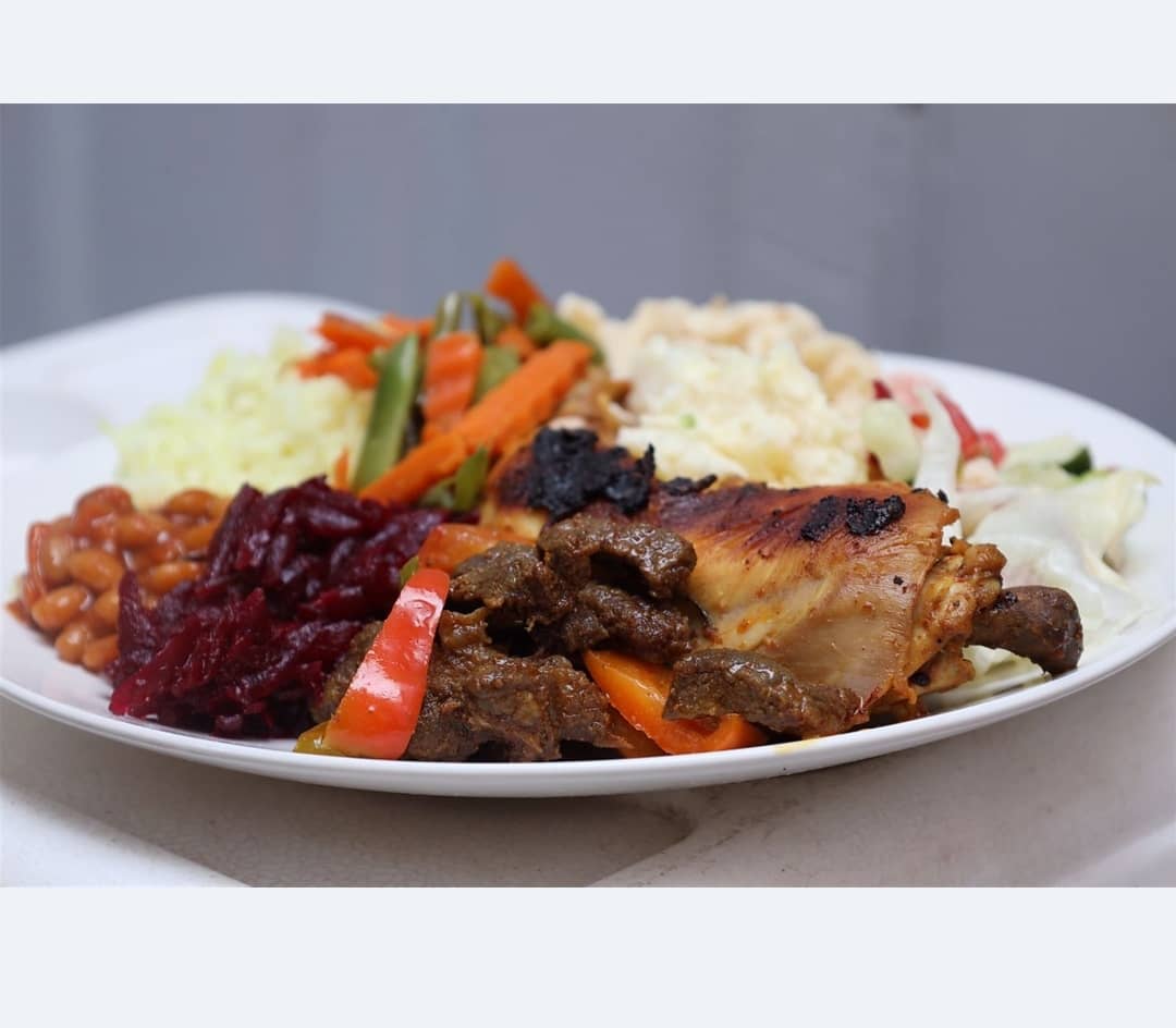 A generous mixed plate with chicken, beef, salads and vegetables